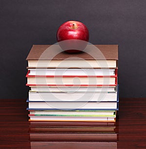 Apple with books on wood desk