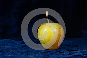 Apple candle on velor dark background