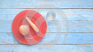Apple and carrot on a red plate and a glass of water, dieting, healthy nutrion photo