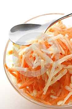 Apple and carrot salad in a glass bowl