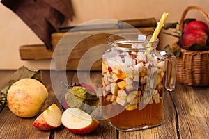 Apple cider sangria in a glass jar on wooden table