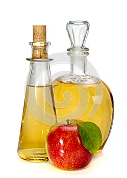 Apple cider vinegar in a glass vessel and red apple