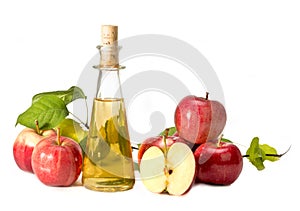 Apple cider vinegar in a glass vessel and red apples