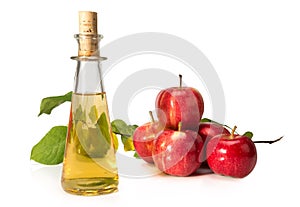 Apple cider vinegar in a glass vessel and red apples