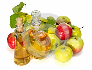 Apple cider vinegar in a glass vessel and red and green apples