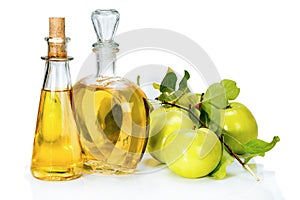 Apple cider vinegar in a glass vials and green apples