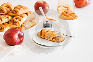 Apple cinnamon pastry rolls on white wooden table