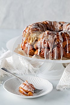 Apple cinnamon pull apart cake with a piece on a plate in front.