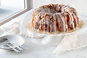 An apple cinnamon pull apart coffee cake drizzled with icing, ready for serving.