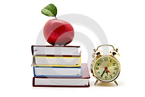 Apple, clock and books