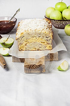 Apple and coconut loaf cake on wooden cutting board