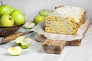 Apple and coconut loaf cake on wooden cutting board