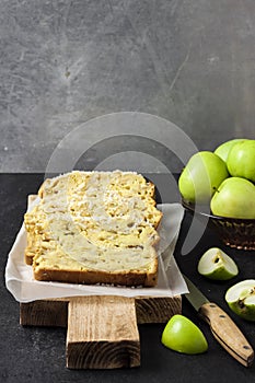 Apple and coconut loaf cake on wooden cutting board