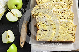 Apple and coconut loaf cake on wooden cutting board