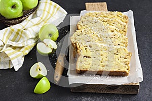 Apple and coconut loaf cake on wooden cutting board