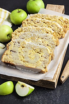 Apple and coconut loaf cake on wooden cutting board