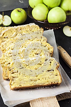 Apple and coconut loaf cake on wooden cutting board