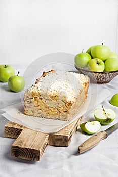 Apple and coconut loaf cake on wooden cutting board