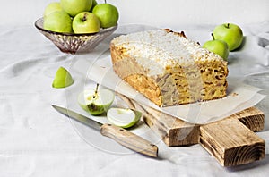 Apple and coconut loaf cake on wooden cutting board