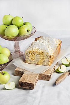 Apple and coconut loaf cake on wooden cutting board