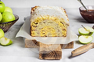 Apple and coconut loaf cake on wooden cutting board