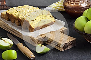 Apple and coconut loaf cake on wooden cutting board