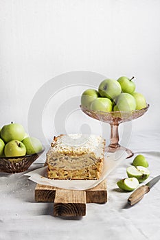 Apple and coconut loaf cake on wooden cutting board