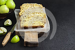 Apple and coconut loaf cake on wooden cutting board