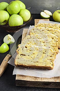 Apple and coconut loaf cake on wooden cutting board