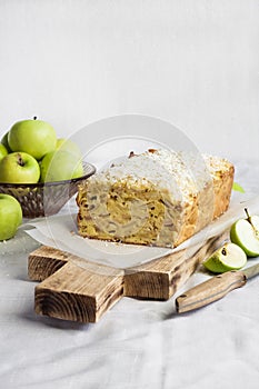 Apple and coconut loaf cake on wooden cutting board