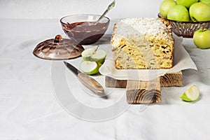 Apple and coconut loaf cake on wooden cutting board
