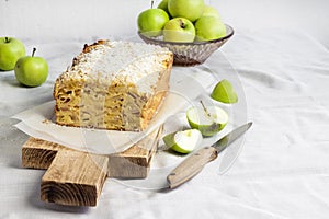 Apple and coconut loaf cake on wooden cutting board