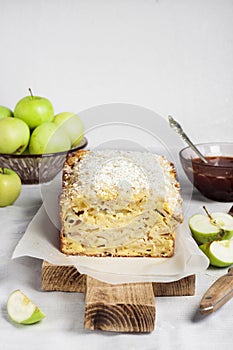 Apple and coconut loaf cake on wooden cutting board