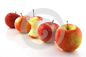 Apple core among whole apples, focus on the core