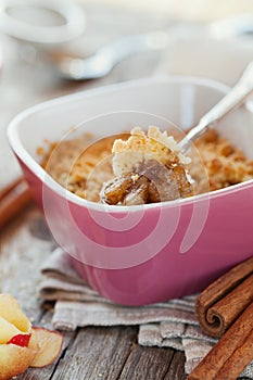 Apple crumble with cinnamon on rustic table