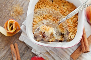 Apple crumble with cinnamon on rustic table