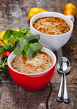 Apple crumble in two cups on wooden rustic background.