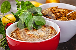 Apple crumble in two cups on wooden rustic background.