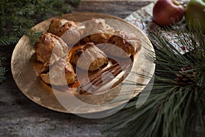 Apple Dumplings on Gold Plate with Greenery on Rustic Wood