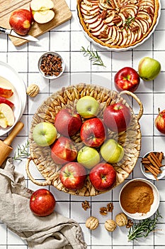 Apple. Fresh raw juicy red and green apples in a basket on a kitchen table with ingredients for cooking