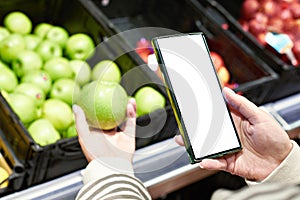 Apple fruit in hand and smartphone