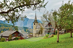 Apple garden in front of the old parish church on a cloudy autumn day. Grundlsee, Styria, Austria