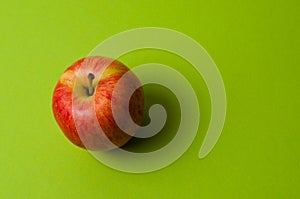 Apple on green background. Healthy eating, calorie count and weight loss concept