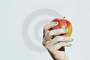 Apple in hand with manicure.beauty salon woman shellac polish nail