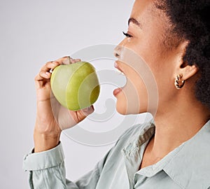 Apple, health and black woman in studio eating for nutrition, wellness and healthy snack. Food, diet and face profile of