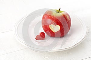 Apple with a heart shaped cut-out on a plate