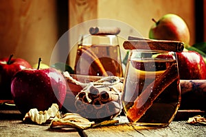 Apple juice with cinnamon in a glass and fresh apples on a vinta