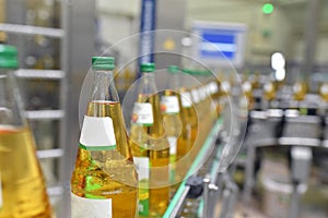 Apple juice in glass bottles in a factory for the food industry - bottling and transport