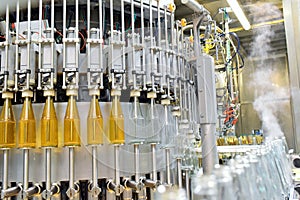 Apple juice in glass bottles in a factory for the food industry - bottling and transport