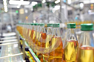 Apple juice in glass bottles in a factory for the food industry - bottling and transport